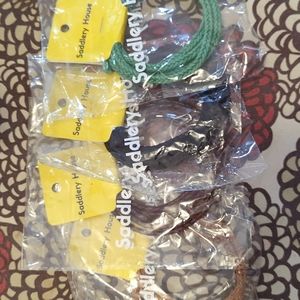 Four round braided leather chords, black,  browns, and green. Saddlery House.